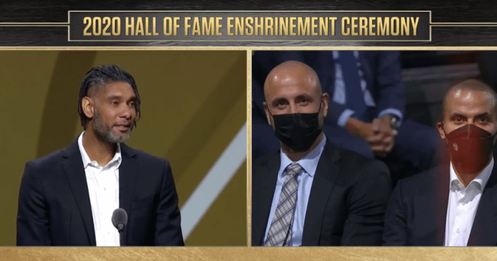 An image of Tim Duncan, Manu Ginobili, and Tony Parker at the 2021 Basketball Hall of Fame Enshrinement Ceremony with a black and gold border and gold lettering